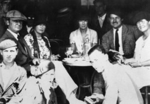 Black and white image of Ernest Hemingway and Elizabeth Hadley at a cafe with friends. 