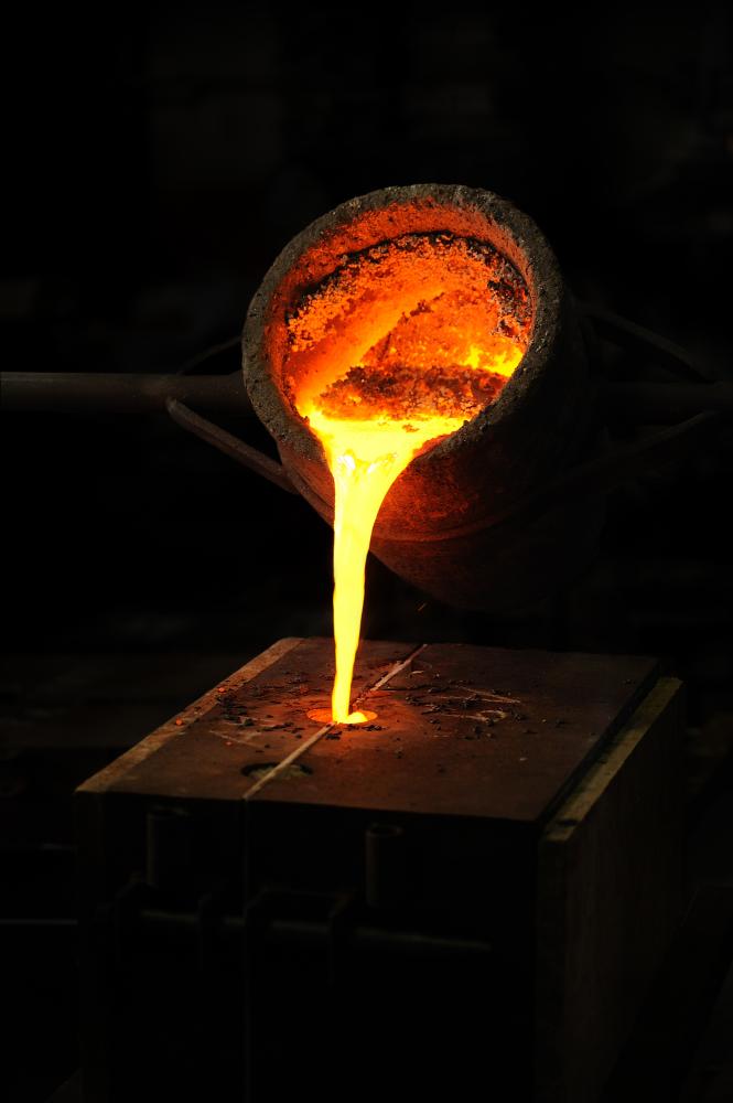 Liquid metal pouring from a bucket into a mold.