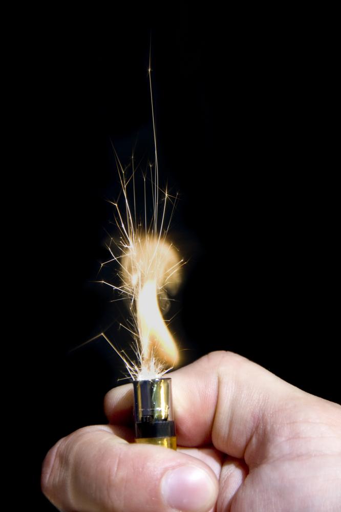 A hand igniting a lighter with a tall yellow flame.
