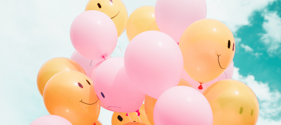 Yellow and pink smiley face balloons, symbolizing mindset habits that rise like air
