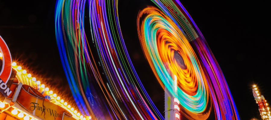 Lit up Ferris wheel creating momentum as it spins