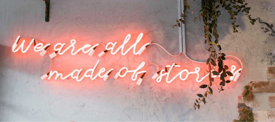 Neon sign reading "we are all made of stories" to encourage you to tell your story