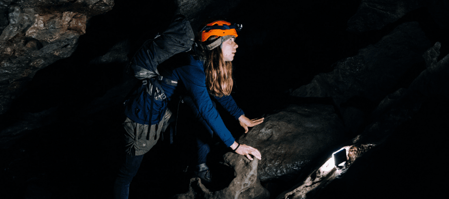 Person spelunking in cave to symbolize trust in getting started