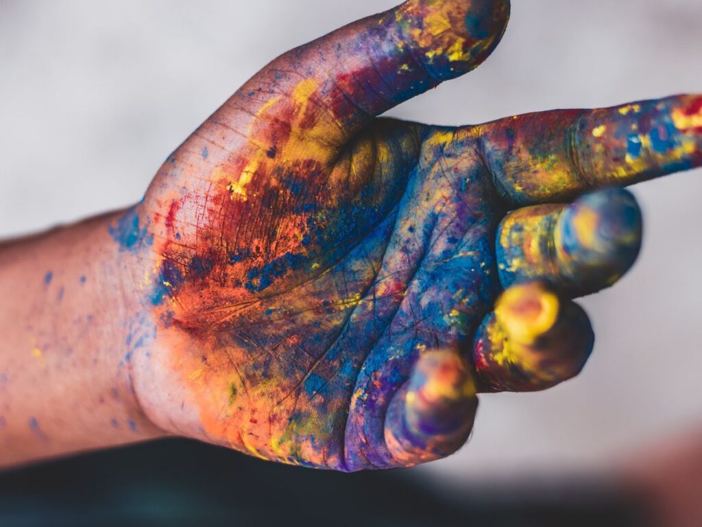 Finding your true self, hand reaching out with colorful paint on it