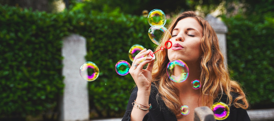 Woman blowing bubbles, colorful bubbles, the power of play