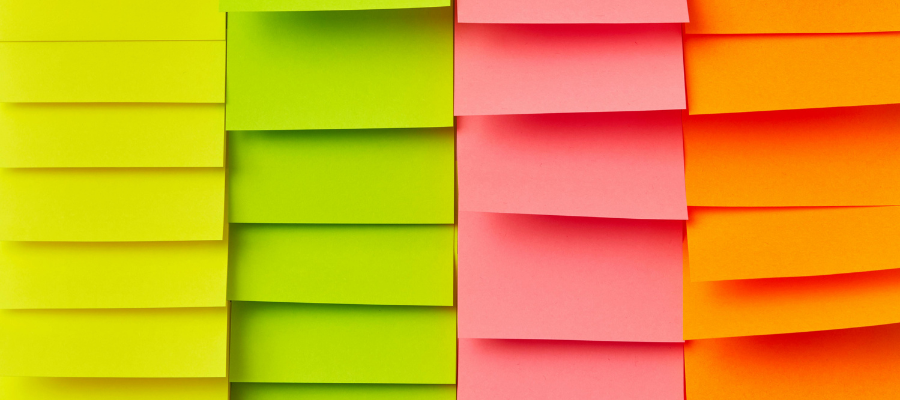 Photo of brightly colored yellow, green, pink, and orange sticky notes to symbolize endless to-do lists and how you can handle stress that can comes from them