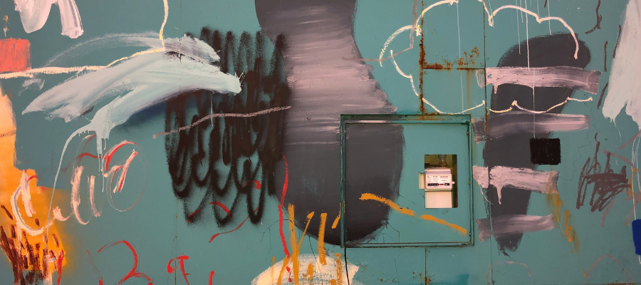 painted doodle mural in gray, black, white and yellow outlines resembling a stormy sky over a teal wall, representing a scattered mind