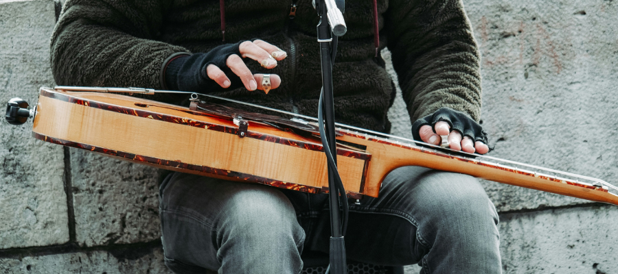 creative expression; cropped photo of a person sitting holding a guitar to represent Susie's encounter with authentic creative expression