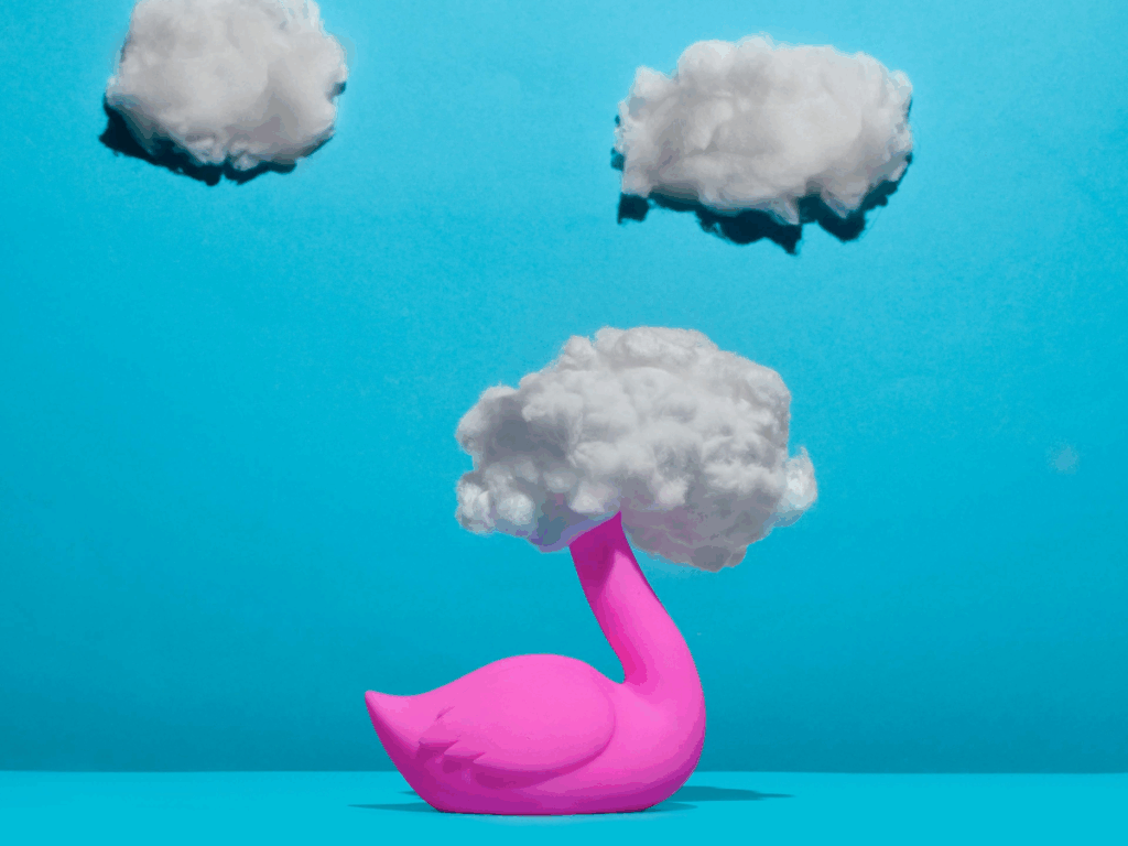 Creative thinking comes from mental clarity; an artistic portrayal of a pink plastic bird with cotton covering its head, like a cloud, represents the mental fog that needs to clear before creative thinking can happen.