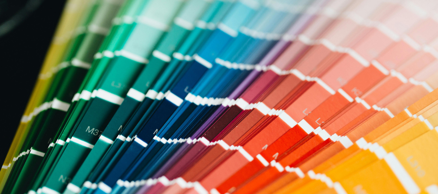Color of the Year, a close-up view of a stack of paint color swatches fanned out showing all different shades of green, blue, pink, red, orange and yellow.