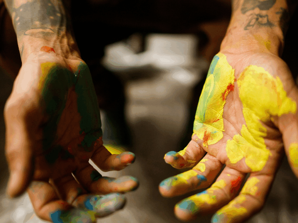 being your authentic self; open hands covered in paint represent being your authentic self