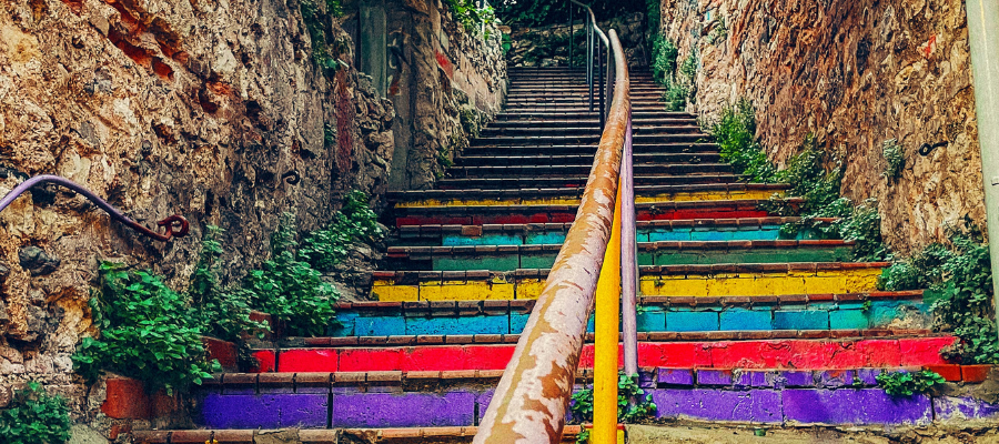 distress tolerance; a colorful, winding, paint-shipped staircase represents the importance of distress tolerance in creative endeavors - the ability to stay with it and keep going in the face of uncertainty or challenges.