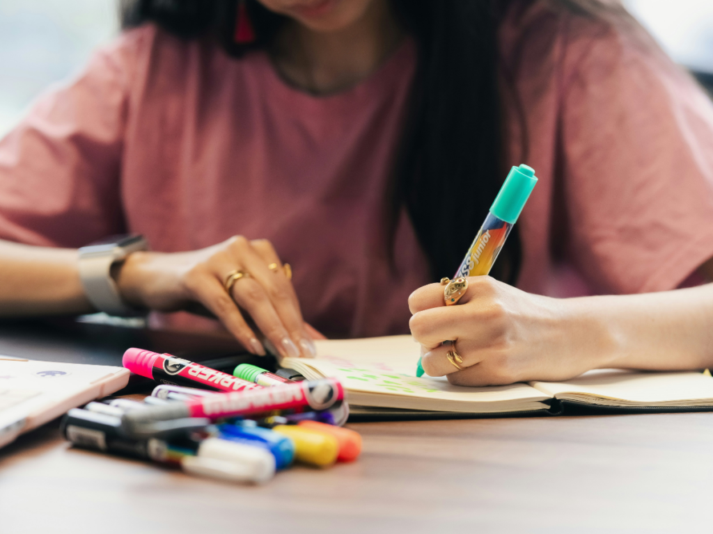 meaningful creation; image of a woman's hands journaling with colorful markers