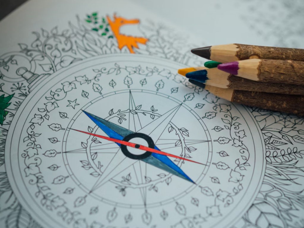 trust your intuition; image of a partially colored compass on a coloring page with colored pencils symbolizes learning to trust your intuition again. 