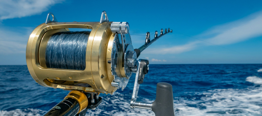 close up of a fishing rod with the line in the ocean off the back of a boat represents how Susie discovered her drag path, the things holding her back as she struggled to move forward.