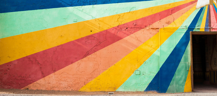 a mural on a building with colorful lines that radiate out over an open doorway represent how the right content can help you get whatever you want